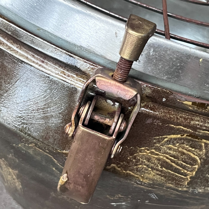 Close-up of brass toggle clamp and screw catch on vintage VEB industrial ceiling light