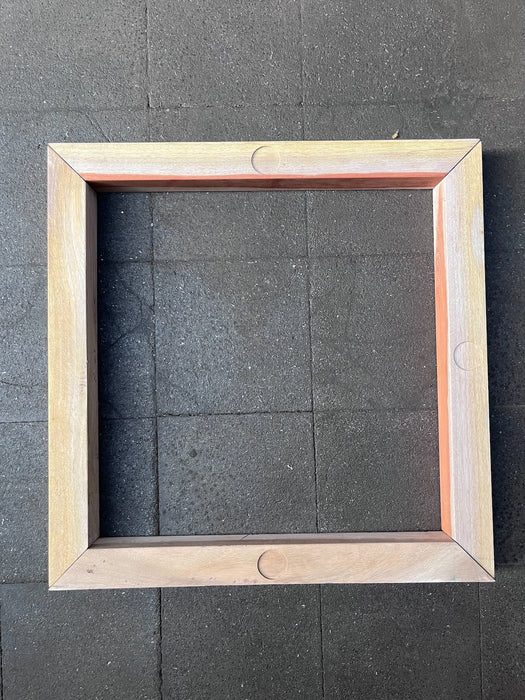 Close-up of the mitred end of a hardwood divider piece showing the grain and red-brown heartwood edge