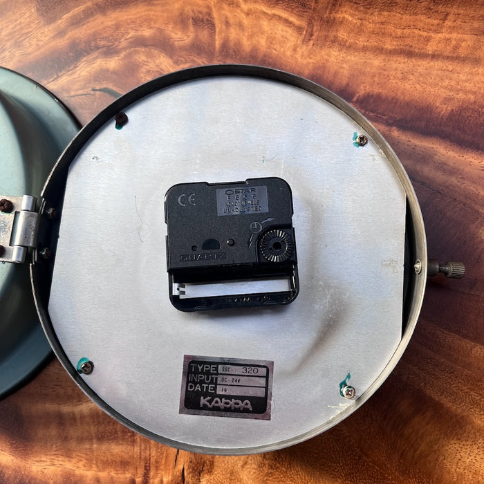 Kappa ship's clock with hinged bezel open showing rating plate Type SSC-320, 24V DC, and quartz movement