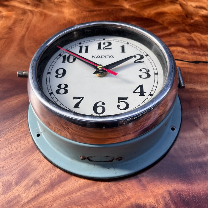 Angled view of Kappa marine wall clock showing chrome bezel and original sea green painted case