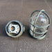Salvaged marine cage light taken apart, cast brass body with ceramic lampholder beside the guard and glass dome