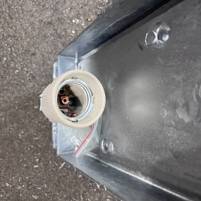 Back of an aluminium marine bulkhead light showing mounting holes and cable entry