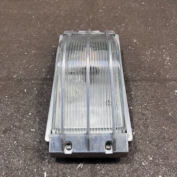 Aluminium marine bulkhead light, side profile showing curved guard over ribbed glass
