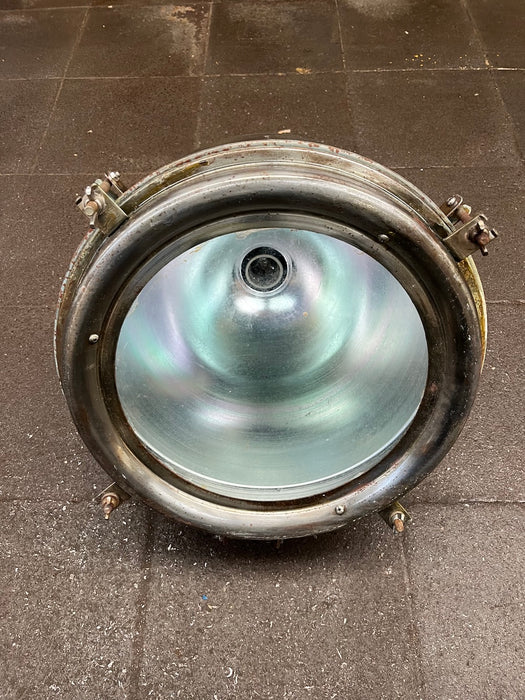 Inside of salvaged pendant light showing polished reflector and ceramic lamp holder