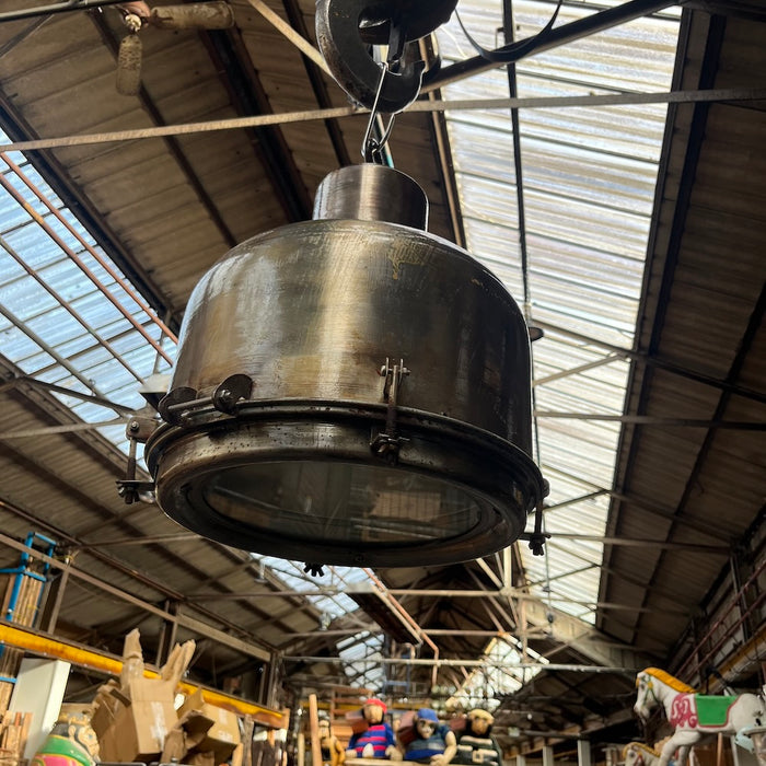Salvaged spun steel pendant light hanging in the warehouse, polished lacquered finish