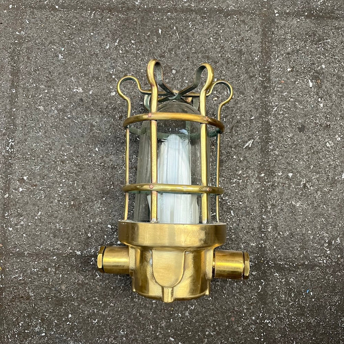 Palazzoli brass passageway light taken apart, showing cage and glass dome beside base and lamp holder