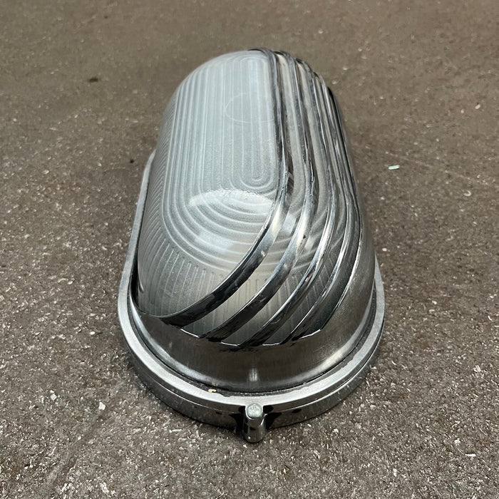 Black oval aluminium bulkhead light with frosted glass and louvred guard
