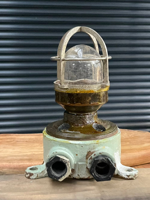 Salvaged mini cast iron marine security light with red painted base, glass dome and guard cage